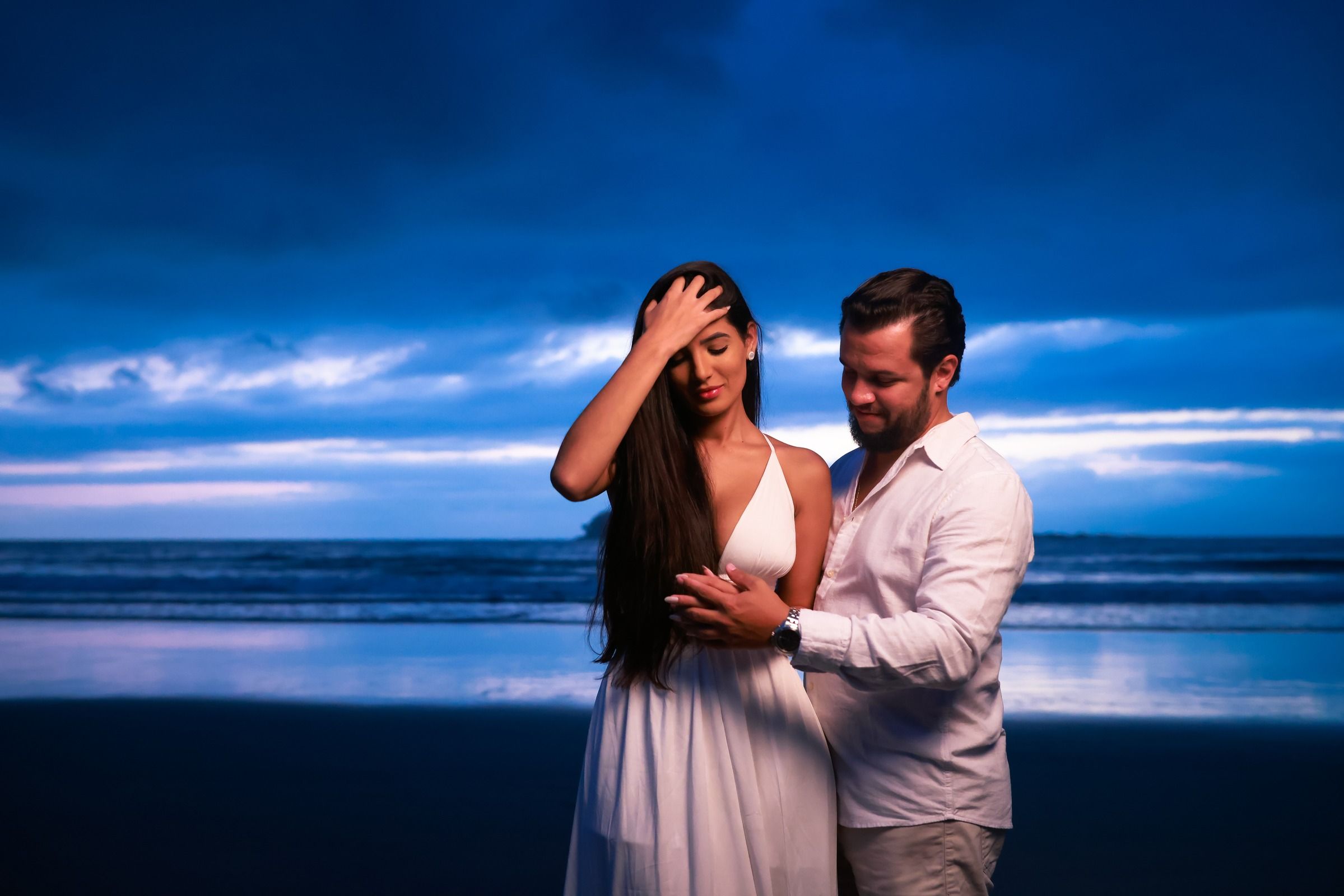 O casal na beira do mar no fim da tarde